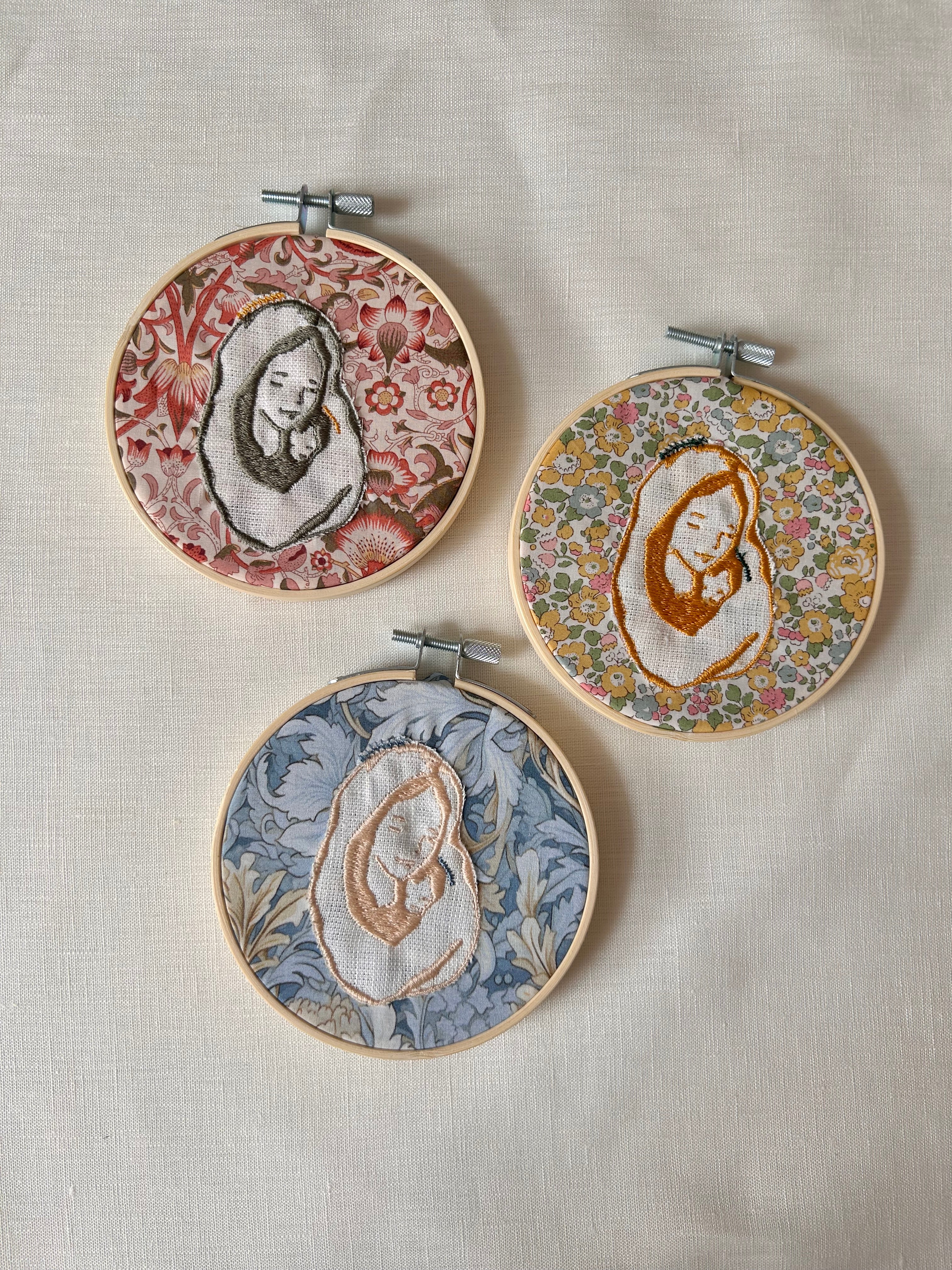 Tres diseños de tela con virgen bordada cada una de un color distinto