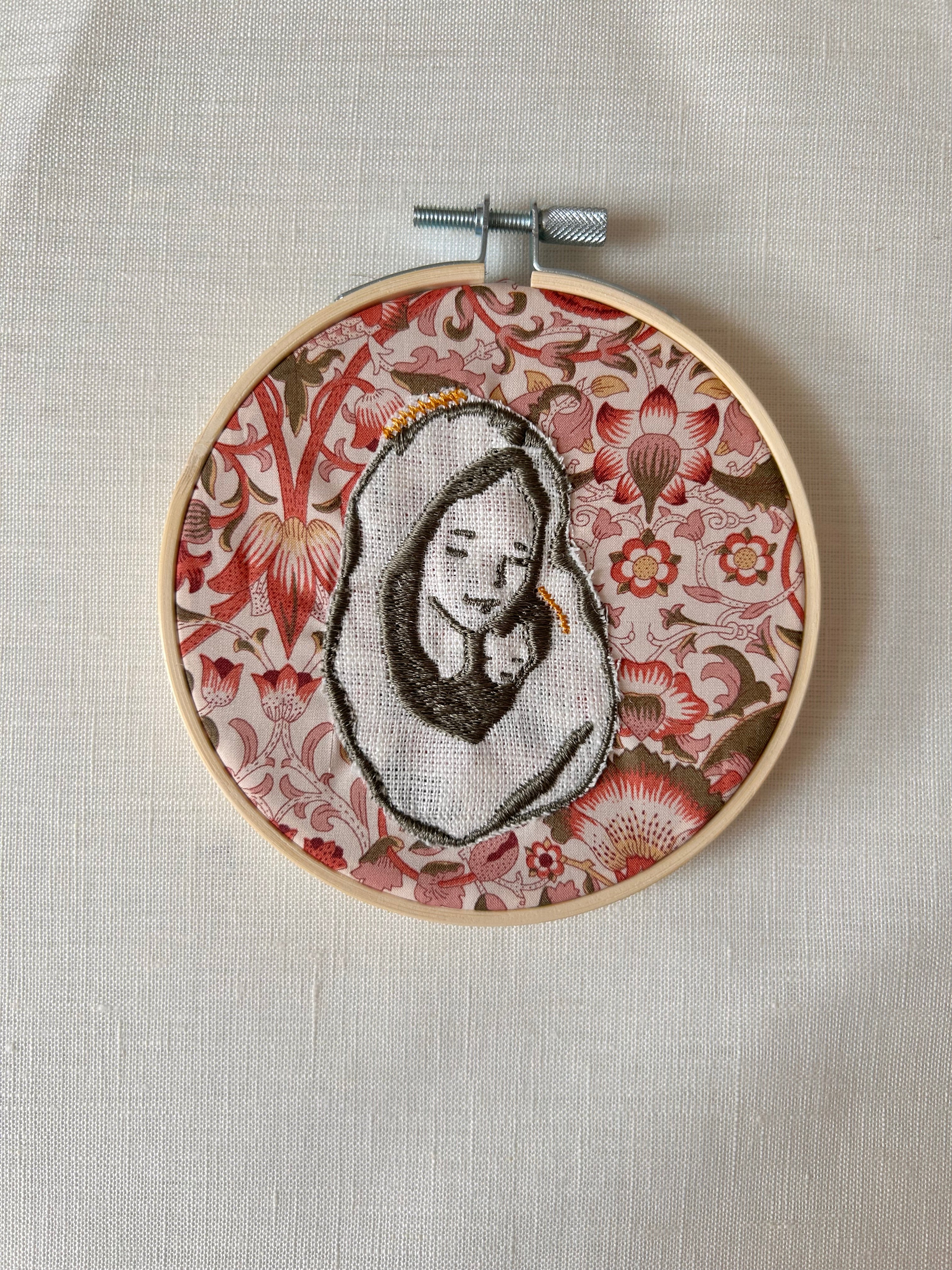 Virgen bordada sobre tela de color amarillo sobre rojo intenso